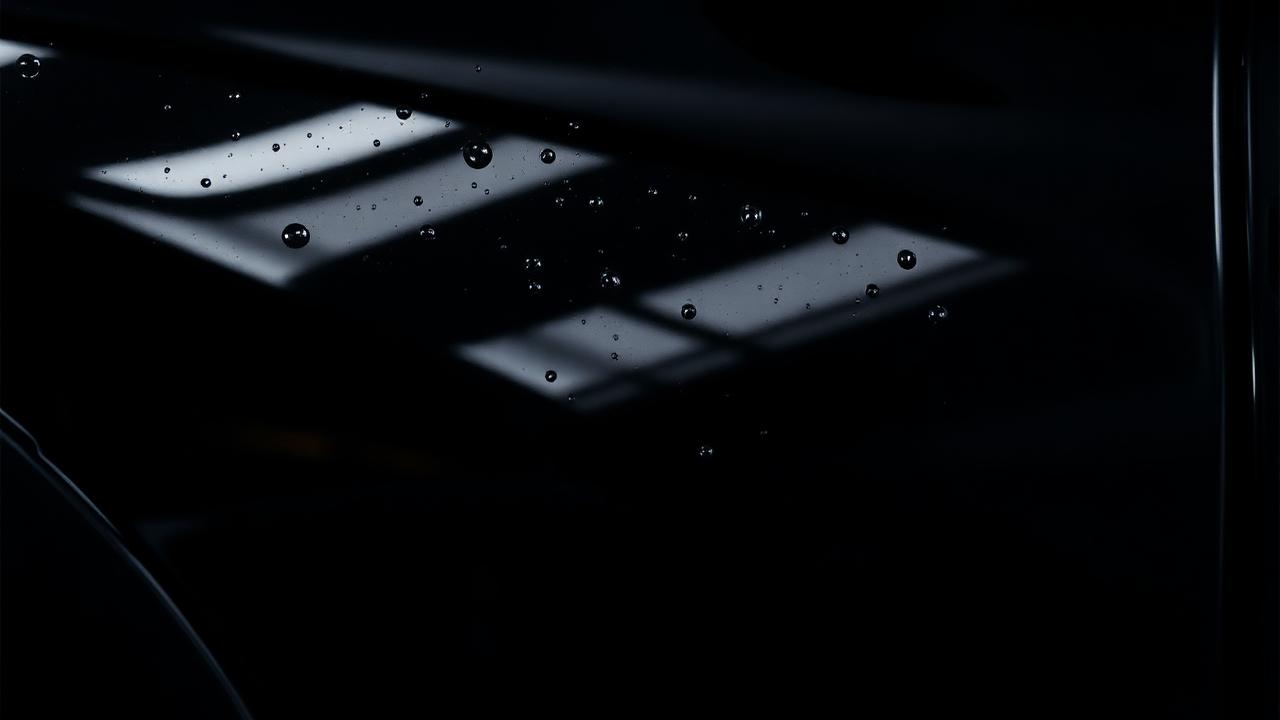 Glossy black car panel with water beading after clear coat paint protection in Midland TX